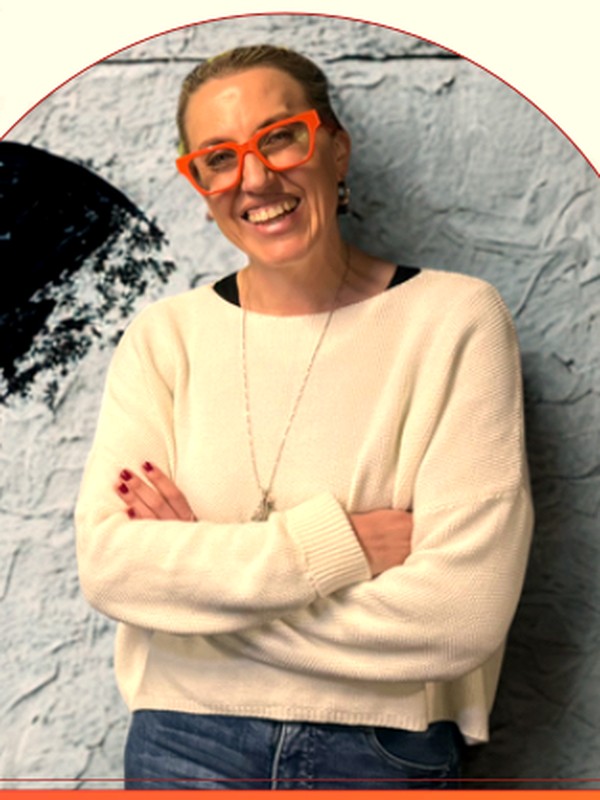 Leah Veenhuizen, founder of Nuanced Co., smiling in orange glasses